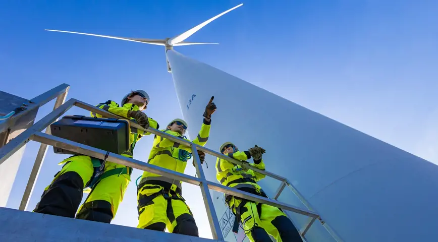 Engineers standing beneath a wind turbine