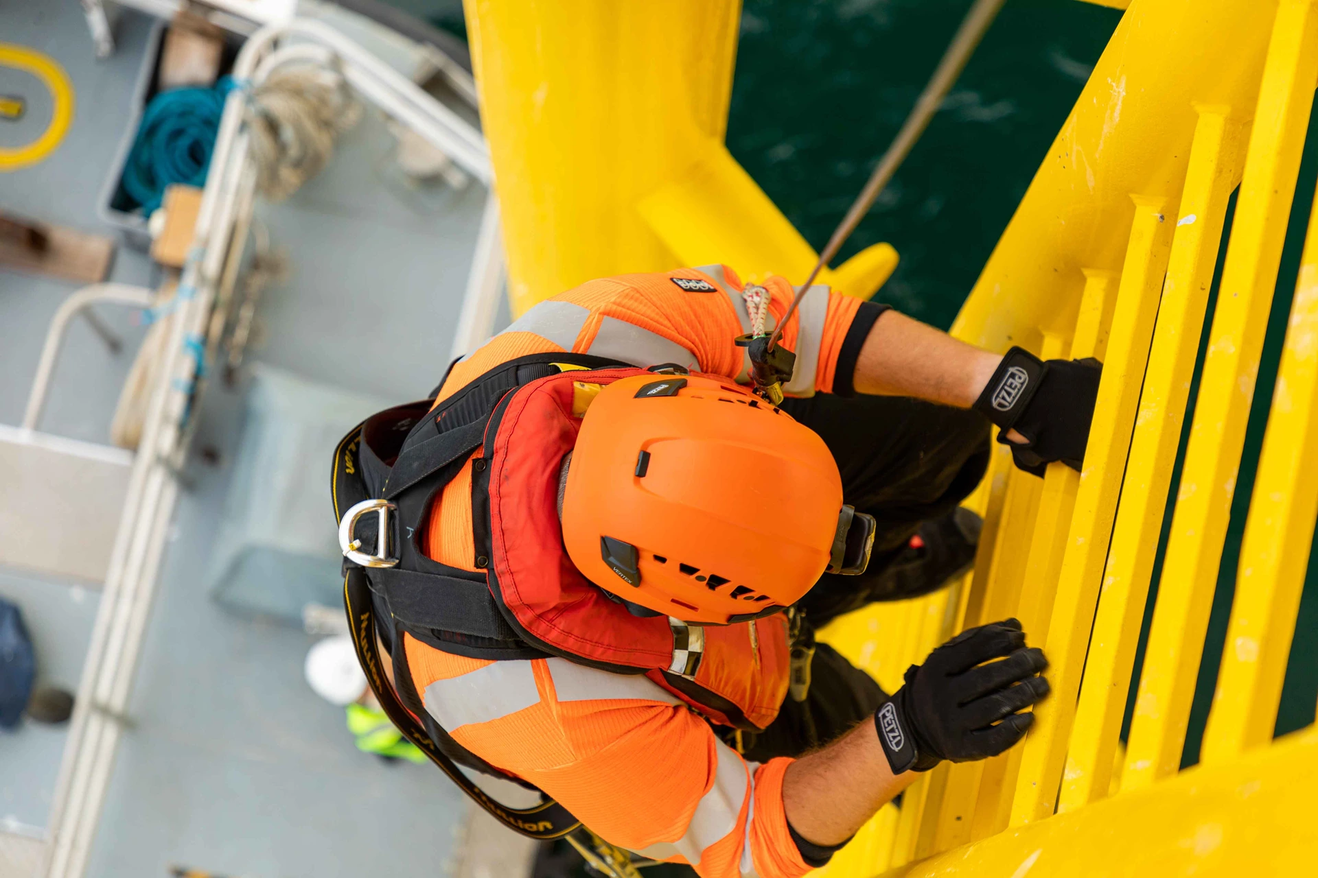 Offshore technician climbing a wind turbine ladder